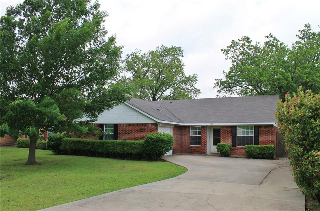 a front view of a house with a yard and trees