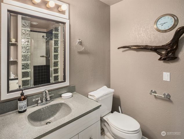 a bathroom with a sink a toilet a mirror and shower