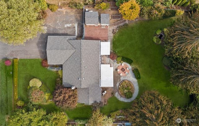an aerial view of a house with garden space ocean and trees all around