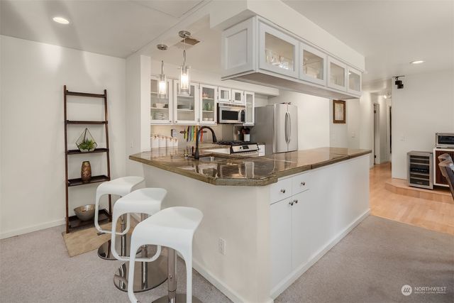 a kitchen with kitchen island a dining table chairs sink and cabinets