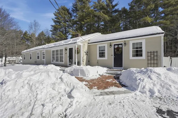 a view of a house with a yard covered in snow