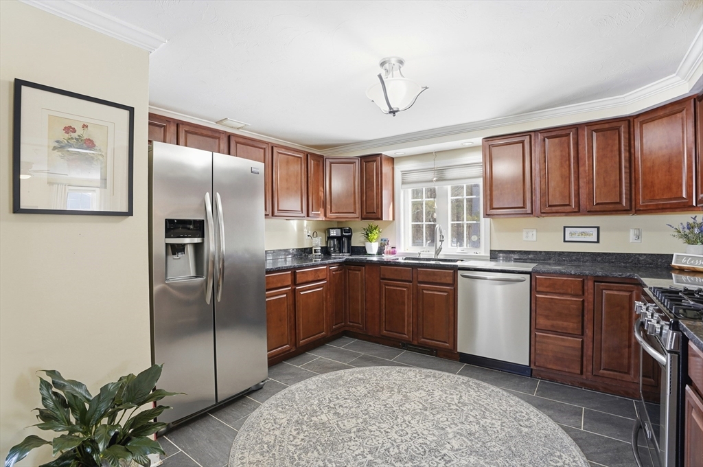 9 Kanehoe Court Townsend, MA 01474 - Photo 7 of 31 a kitchen with stainless steel appliances granite countertop a refrigerator a sink dishwasher a stove with wooden cabinets and floor