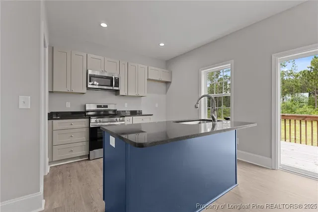 a kitchen with granite countertop a sink stove and cabinets