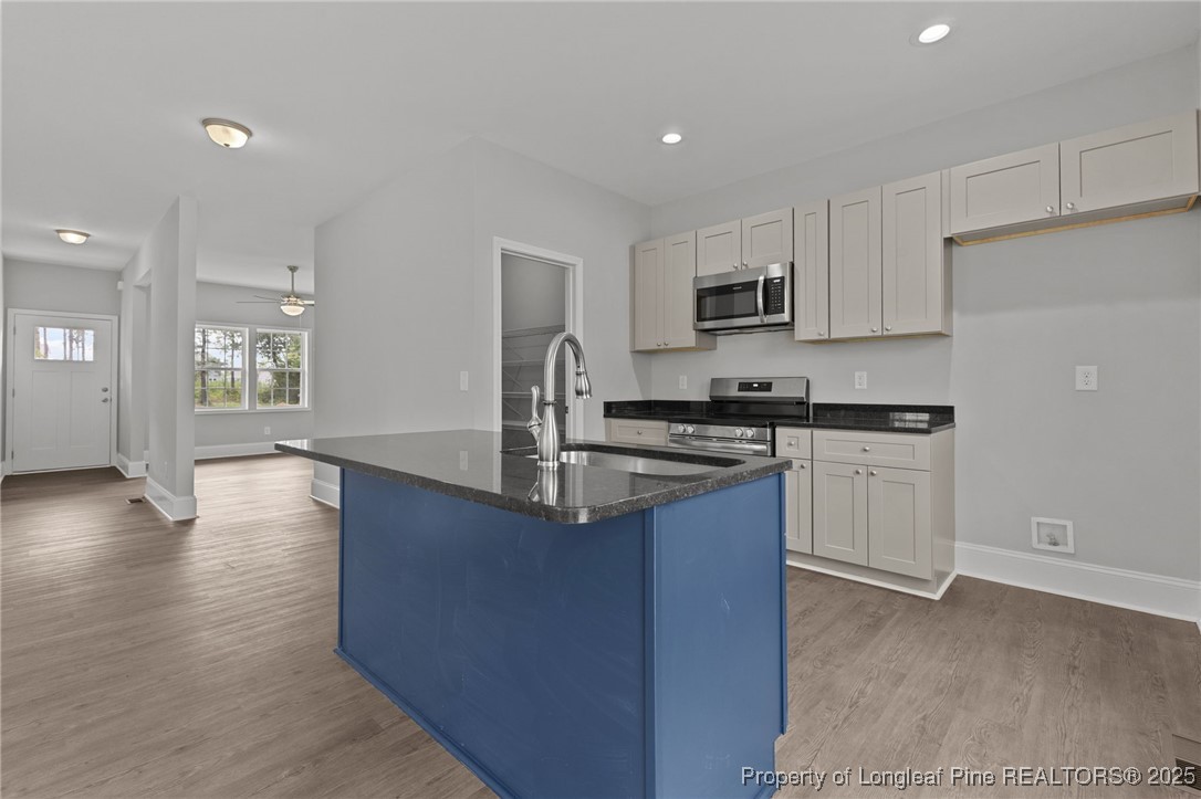 533 Stadium Drive Cameron, NC 28326 - Photo 12 of 42 a kitchen with granite countertop a sink stove and cabinets
