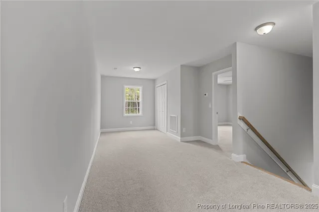 an empty room with wooden floor ceiling fan and windows