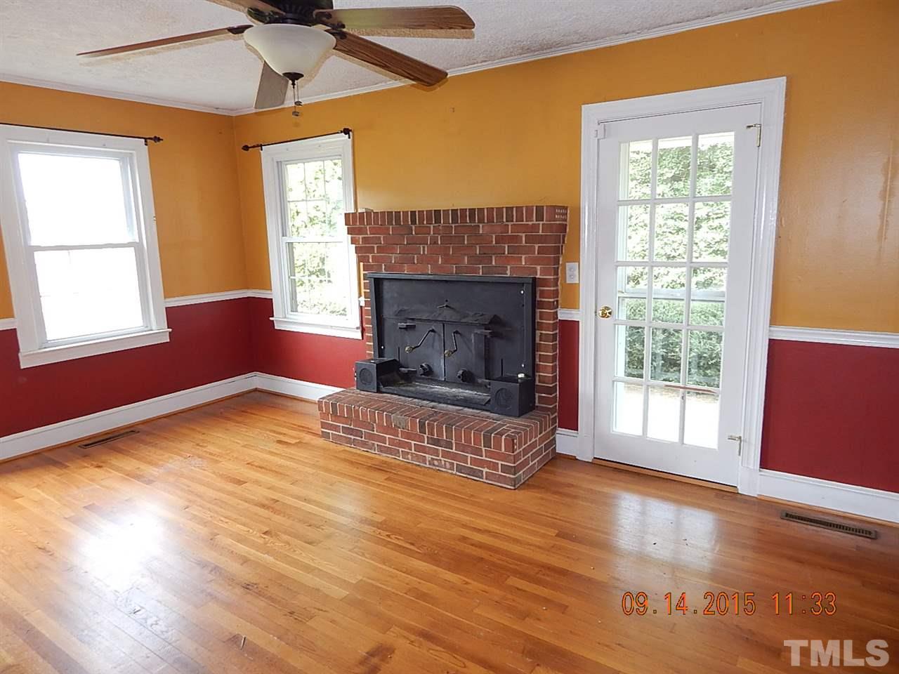197 Thee Hester Road Roxboro, NC 27574 - Photo 4 of 16 a view of an empty room with wooden floor fireplace and a window