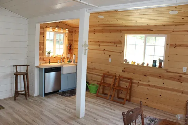 a view of a entrance and a livingroom with wooden floor