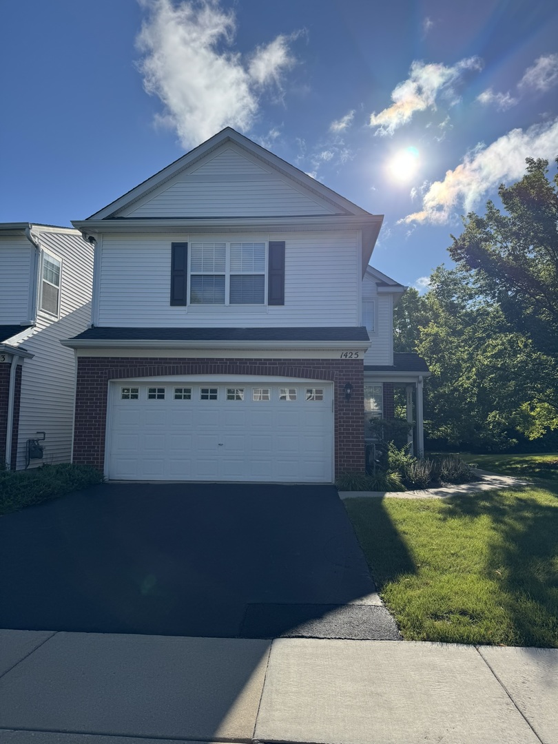 1425 Millbrook Drive Algonquin, IL 60102 - Photo 1 of 11 a front view of a house with a garden
