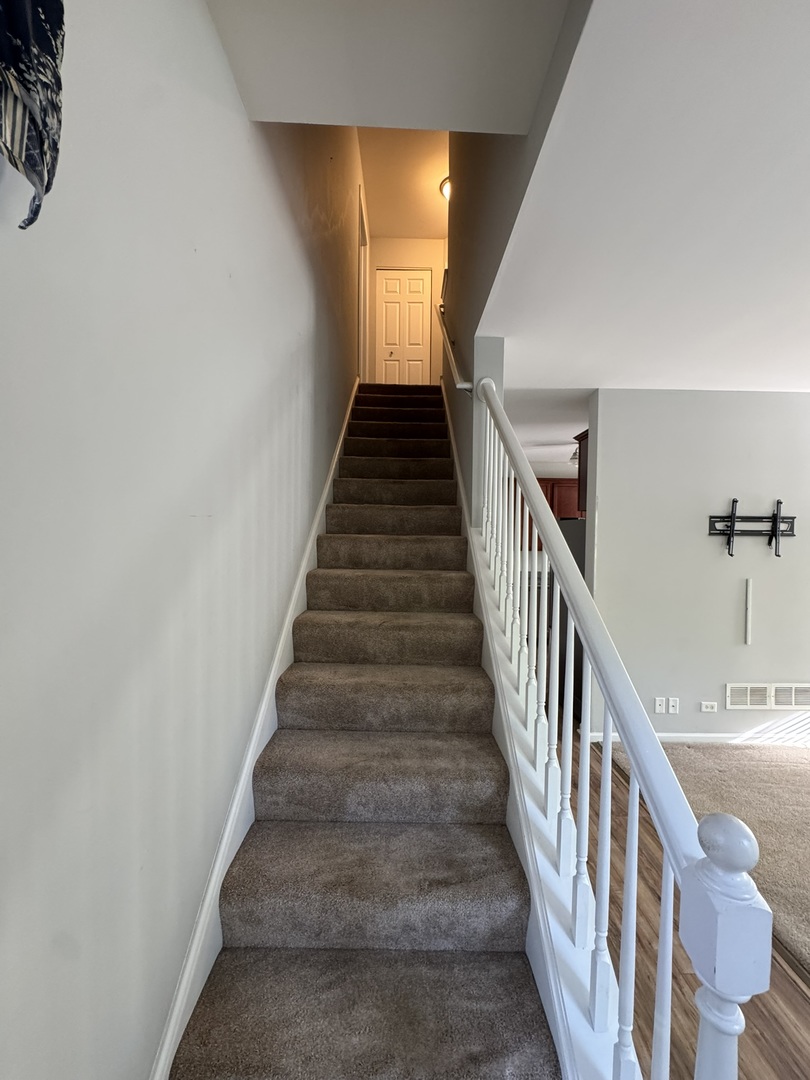 1425 Millbrook Drive Algonquin, IL 60102 - Photo 4 of 11 a view of staircase with wooden floor and white walls