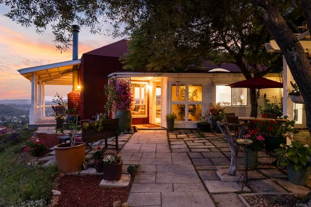 a view of a patio with table and chairs potted plants and a large tree