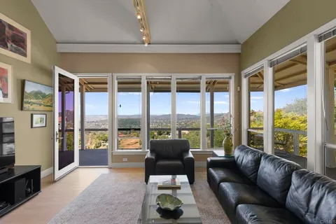 a living room with furniture large windows and a flat screen tv