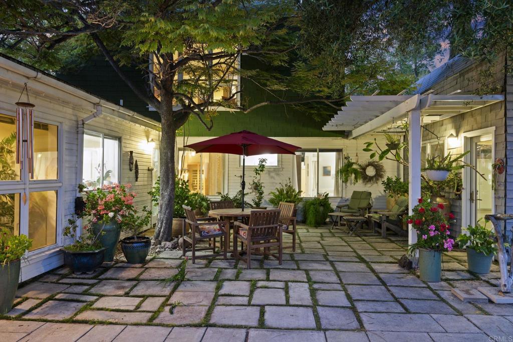 14645 High Valley Road Poway, CA 92064 - Photo 17 of 34 a view of a patio with table and chairs potted plants and large tree