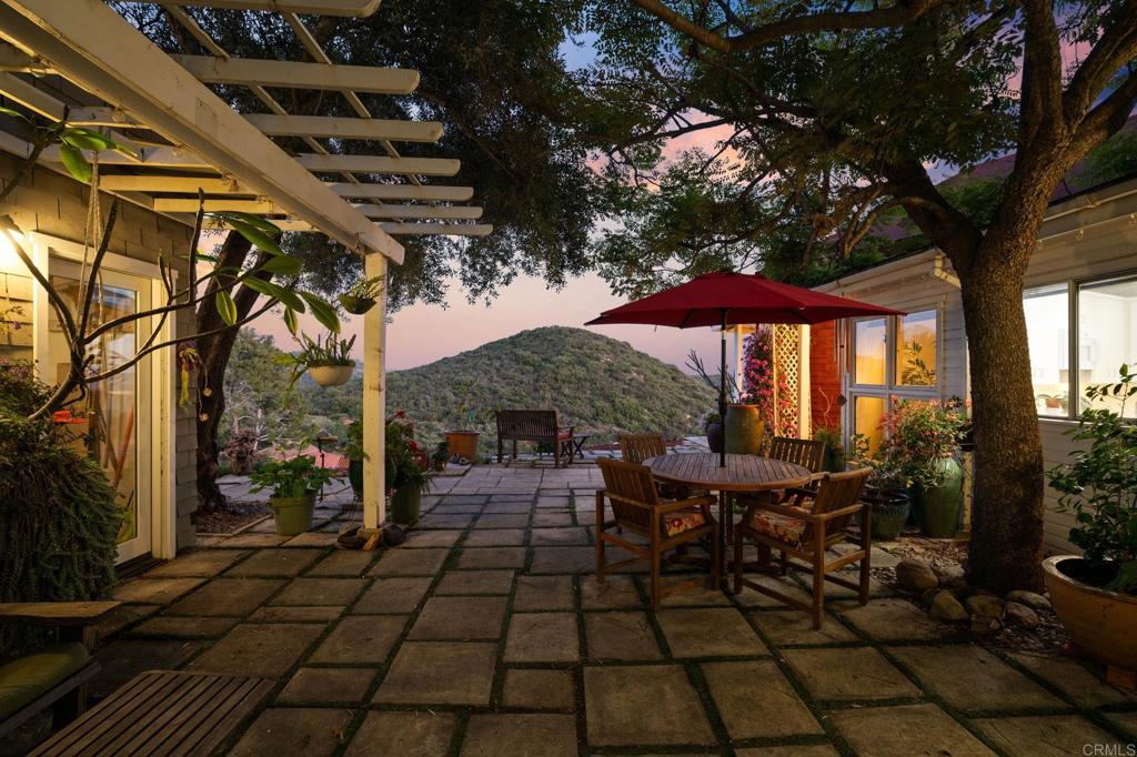 14645 High Valley Road Poway, CA 92064 - Photo 2 of 34 a view of a patio with table and chairs under an umbrella with a barbeque
