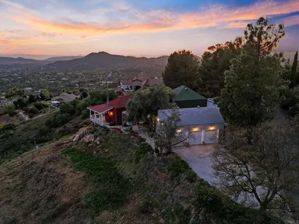 a view of a house with backyard sitting area and garden