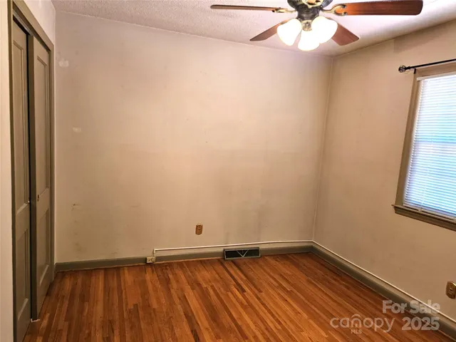 a view of room with window and wooden floor