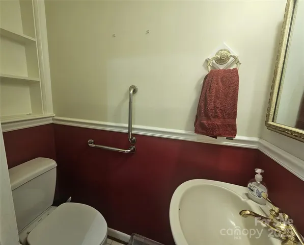 a bathroom with a toilet mirror and vanity