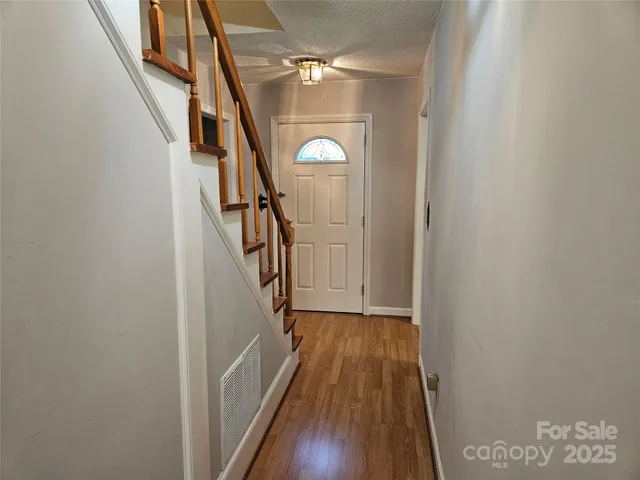 a view of entryway and hall with wooden floor