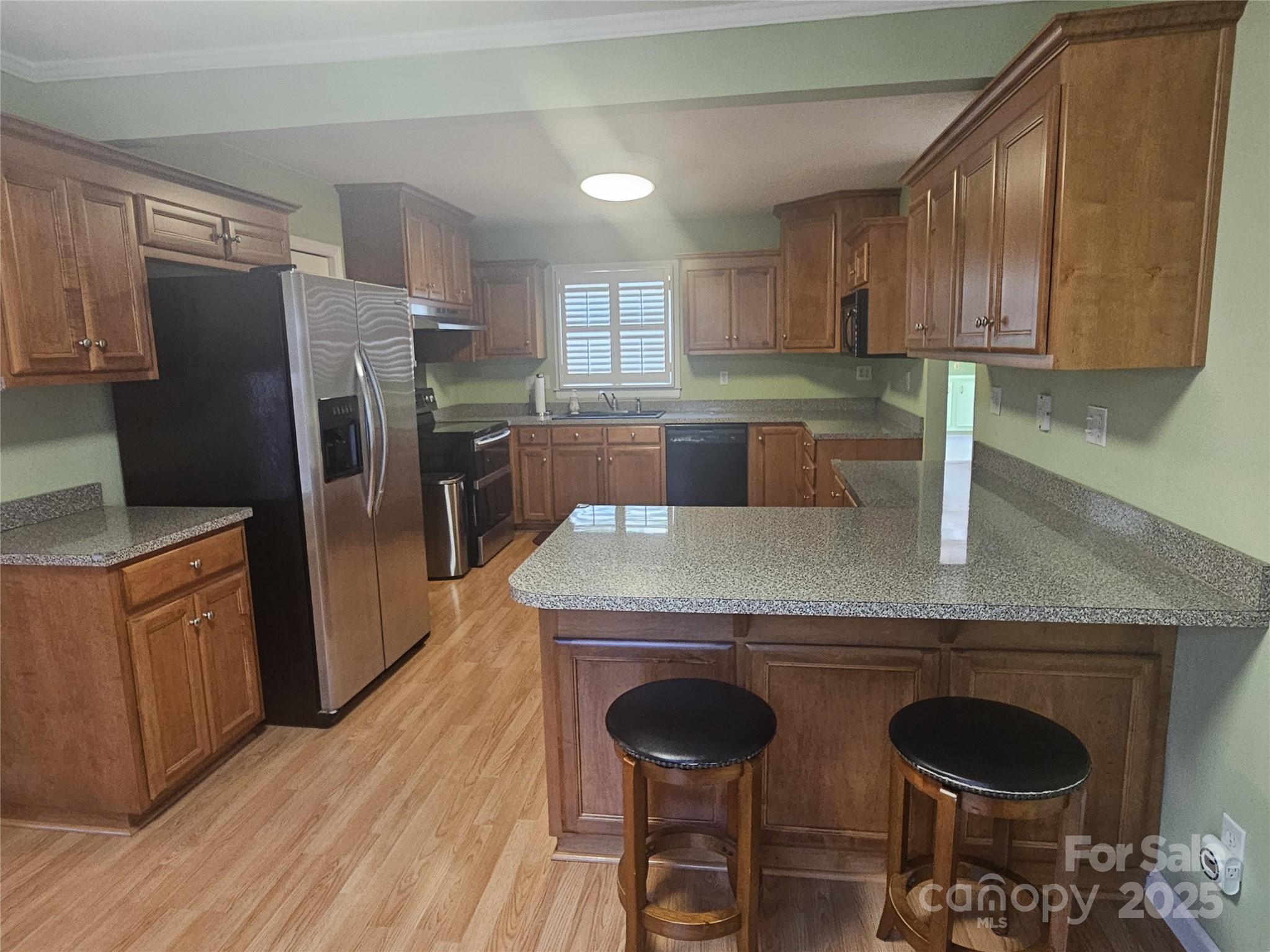 10670 Troutman Road Midland, NC 28107 - Photo 10 of 38 a kitchen with stainless steel appliances granite countertop a refrigerator a stove a sink dishwasher and wooden cabinets with wooden floor