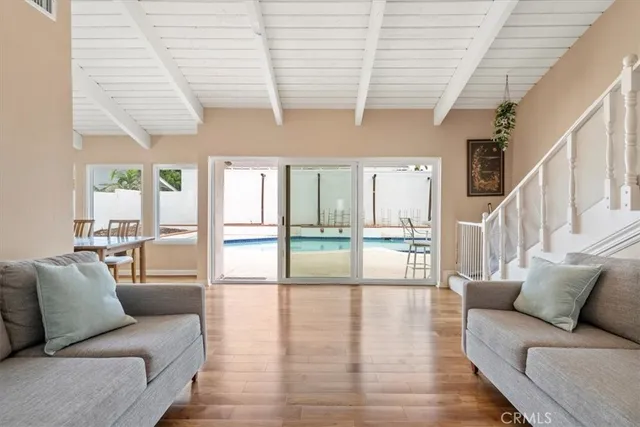 a living room with furniture wooden floor and a large window