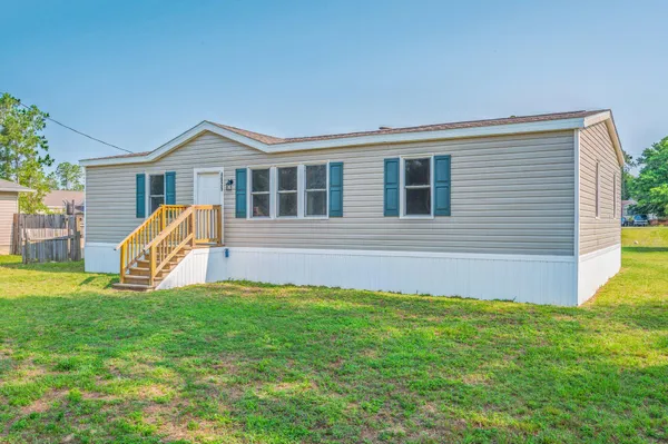 a view of a house with a yard and a porch