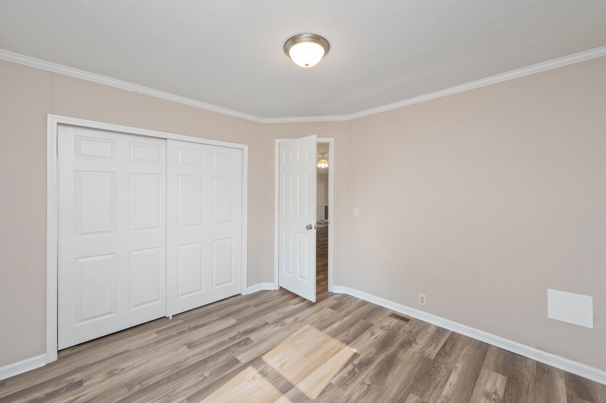 4625 Canary Way Crestview, FL 32539 - Photo 26 of 35 an empty room with wooden floor and windows