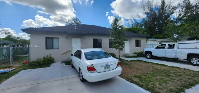 a view of a house with backyard and sitting area