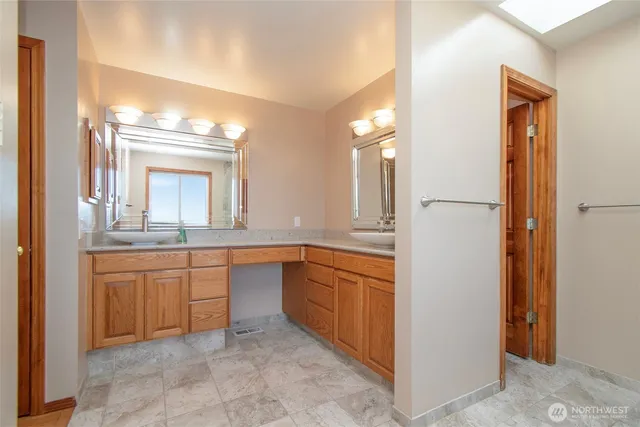 a bathroom with a granite countertop sink and a mirror