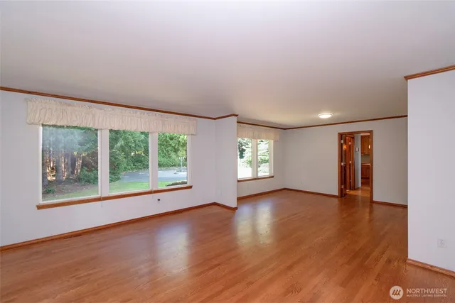 a kitchen with kitchen island granite countertop a sink a stove a microwave cabinets and a dining table