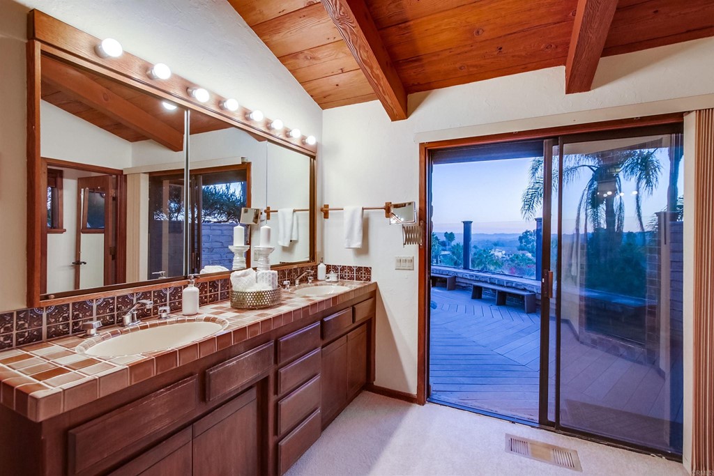 1256 Rancho Encinitas Drive Encinitas, CA 92024 - Photo 13 of 28 a bathroom with a double vanity sink and a mirror