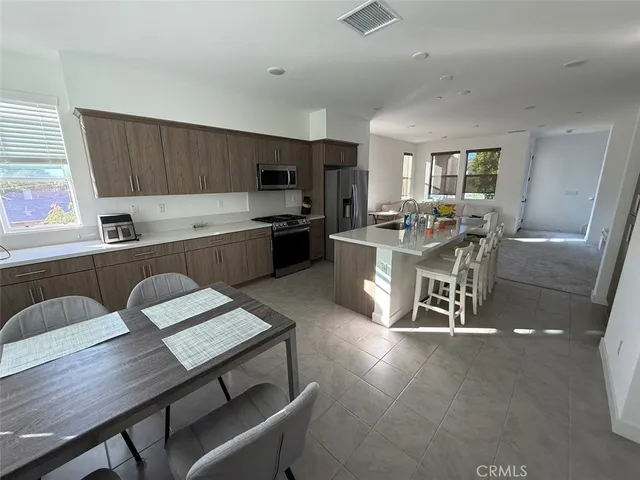 a kitchen with a table chairs microwave and cabinets