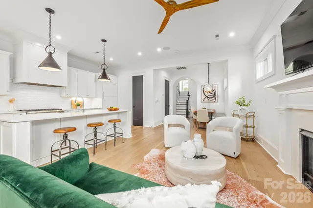 a living room with furniture kitchen view and a chandelier