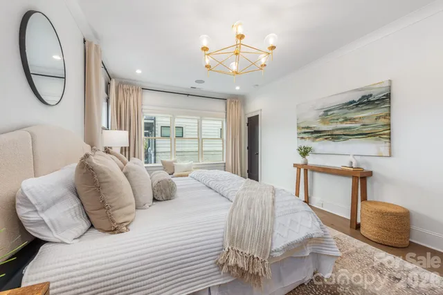 a bedroom with bed and a chandelier