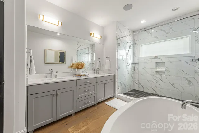 a spacious bathroom with a tub sink shower and mirror