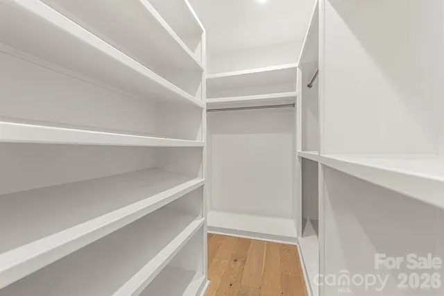 a view of walk in closet with empty racks