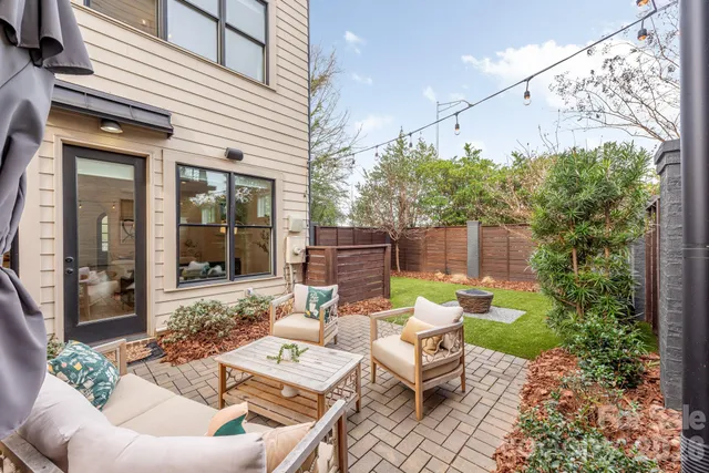 a view of a patio with couches table and chairs and potted plants