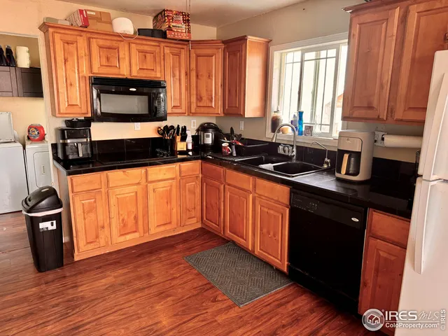 a kitchen with stainless steel appliances a sink a stove a microwave and wooden cabinets