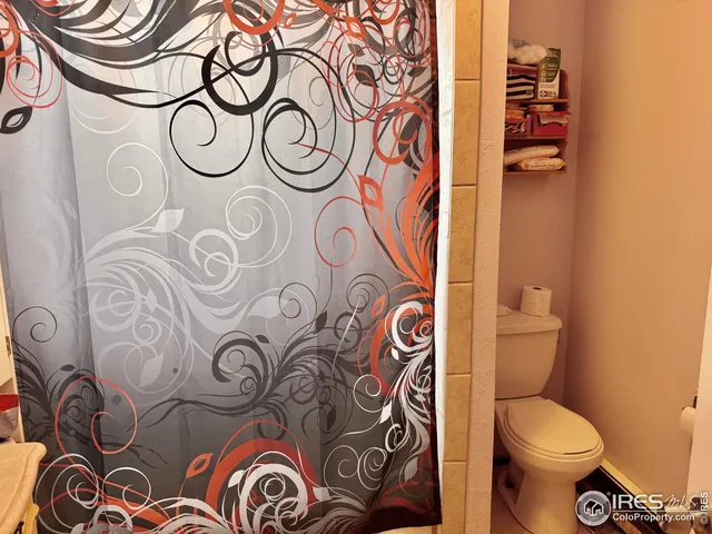a bathroom with a toilet and a shower curtain