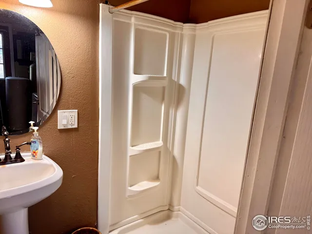 a bathroom with a sink a mirror and a shower