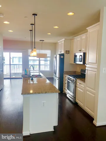 a kitchen with stainless steel appliances granite countertop a sink a stove and a refrigerator