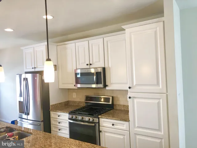 a kitchen with stainless steel appliances white cabinets and a stove