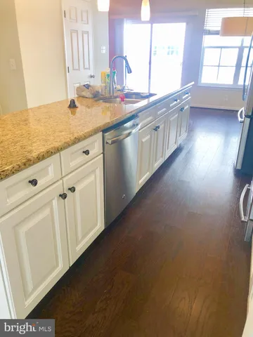 a kitchen with stainless steel appliances granite countertop a refrigerator a stove and a sink