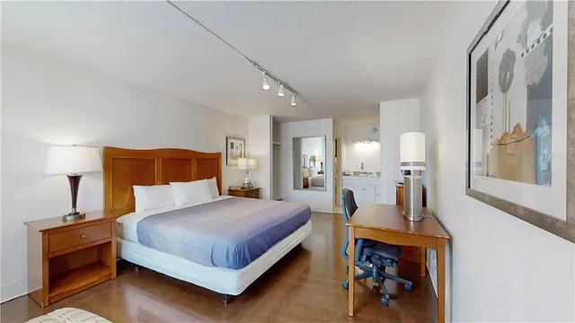 a bedroom with a bed and wooden floor