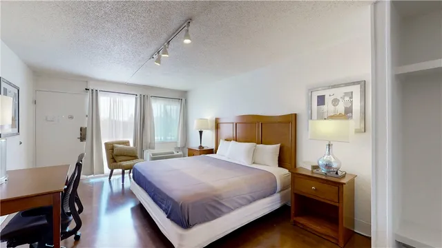 a bathroom with a granite countertop sink a toilet a mirror and shower