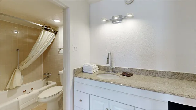 a bedroom with a bed and a flat tv screen on the dresser