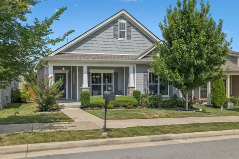 a front view of house with garage and plants
