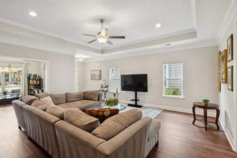 a living room with furniture and a flat screen tv with wooden floor