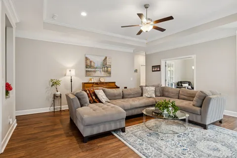a living room with furniture and a ceiling fan
