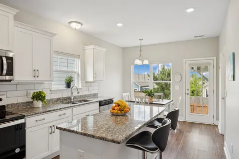 a kitchen with granite countertop a stove a sink and a counter space