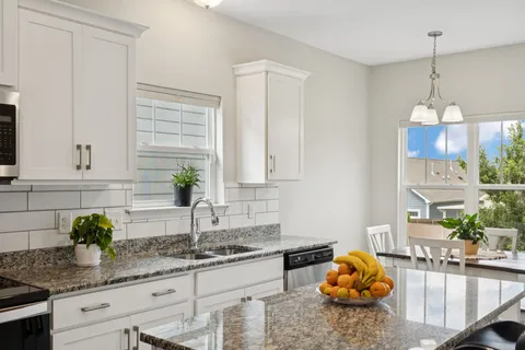 a kitchen with granite countertop a sink a stove and a wooden floor