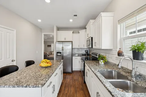 a kitchen with stainless steel appliances granite countertop sink stove and refrigerator